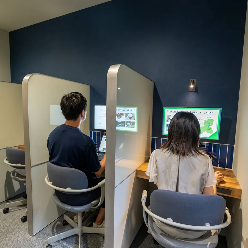 間仕切りのある集中ブースで作業する2人