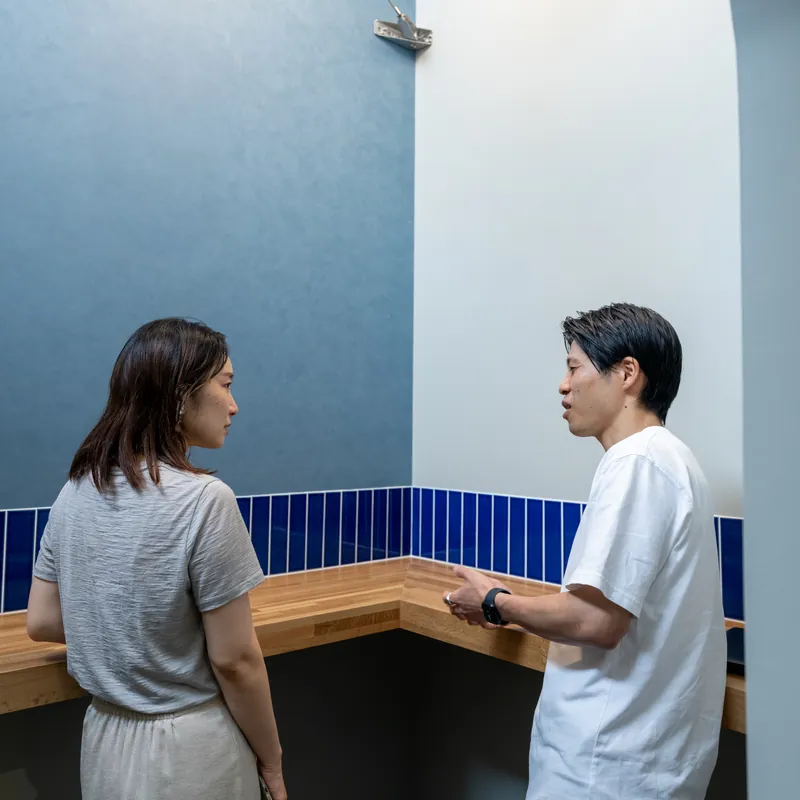 カウンター席で向かい合って話す2人